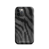 A Charisma Tiger Fur for iPhone with a black and gray striped case featuring a glossy, brushed metal texture. This protective iPhone case, compatible with the iPhone 15 Pro Max, is branded "Statement Cases" at the bottom. The phone's camera lenses are visible in the top left corner.
