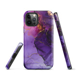 A Statement Cases Golden Orchid Marble for iPhone with a case featuring an abstract design of swirling purple, pink, and gold hues over a white background. The marbled patterns with metallic accents provide dual-layer protection and are impact-resistant. The top of the case has cutouts for the phone's camera lenses and is induction charging compatible.