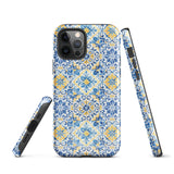 The Blue Mirage for iPhone by Statement Cases features a dual-layered, impact-resistant polycarbonate exterior with a TPU inner liner. Inspired by traditional Portuguese tiles, the blue and yellow patterned case boasts an intricate design of floral and geometric motifs. With its elegant and colorful appearance, the phone's camera is visible at the top left of the case.