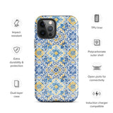 The Blue Mirage for iPhone by Statement Cases features a dual-layered, impact-resistant polycarbonate exterior with a TPU inner liner. Inspired by traditional Portuguese tiles, the blue and yellow patterned case boasts an intricate design of floral and geometric motifs. With its elegant and colorful appearance, the phone's camera is visible at the top left of the case.