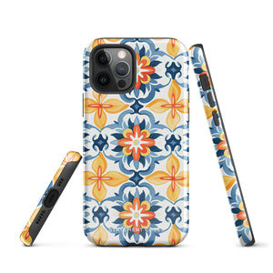 Statement Cases' Mediterranean Bloom for iPhone is showcased, featuring an intricate, colorful pattern. The design includes blue, yellow, and orange floral shapes in a symmetrical arrangement on a light blue background. This durable phone case provides dual-layer protection and is constructed from impact-resistant polycarbonate to safeguard your device.