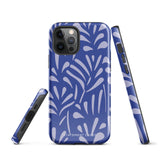 An iPhone encased in the "Mariposa Azul" by Statement Cases, featuring a blue design with an abstract white leaf pattern. The case combines curved and pointed shapes and provides dual-layer protection with TPU lining and impact-resistant polycarbonate. Camera lenses and other top elements remain unobstructed, and "Statement Cases" is inscribed at the bottom.