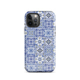 The Lisboa Azul for iPhone by Statement Cases is a smartphone adorned with a dual-layer protection phone case, featuring an intricate blue and white tile pattern. The design showcases various geometric and floral motifs, forming a visually appealing mosaic effect. The impact-resistant camera lenses and flash are prominently visible at the top left.