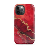 A smartphone in a protective Scarlet Marble for iPhone case by Statement Cases with a red and gold marbled abstract design. The case has "Statement Cases" written at the bottom. The iPhone 15 Pro Max features three camera lenses and a flash on the top left corner.
