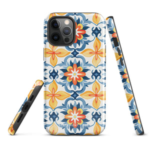 Statement Cases' Mediterranean Bloom for iPhone is showcased, featuring an intricate, colorful pattern. The design includes blue, yellow, and orange floral shapes in a symmetrical arrangement on a light blue background. This durable phone case provides dual-layer protection and is constructed from impact-resistant polycarbonate to safeguard your device.