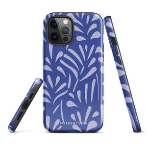 An iPhone encased in the "Mariposa Azul" by Statement Cases, featuring a blue design with an abstract white leaf pattern. The case combines curved and pointed shapes and provides dual-layer protection with TPU lining and impact-resistant polycarbonate. Camera lenses and other top elements remain unobstructed, and "Statement Cases" is inscribed at the bottom.