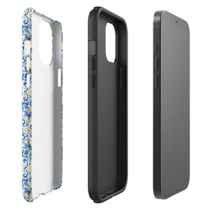 The Blue Mirage for iPhone by Statement Cases features a dual-layered, impact-resistant polycarbonate exterior with a TPU inner liner. Inspired by traditional Portuguese tiles, the blue and yellow patterned case boasts an intricate design of floral and geometric motifs. With its elegant and colorful appearance, the phone's camera is visible at the top left of the case.