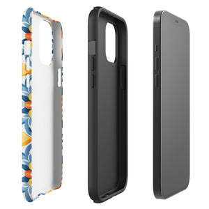 Statement Cases' Mediterranean Bloom for iPhone is showcased, featuring an intricate, colorful pattern. The design includes blue, yellow, and orange floral shapes in a symmetrical arrangement on a light blue background. This durable phone case provides dual-layer protection and is constructed from impact-resistant polycarbonate to safeguard your device.