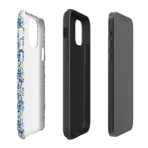 The Blue Mirage for iPhone by Statement Cases features a dual-layered, impact-resistant polycarbonate exterior with a TPU inner liner. Inspired by traditional Portuguese tiles, the blue and yellow patterned case boasts an intricate design of floral and geometric motifs. With its elegant and colorful appearance, the phone's camera is visible at the top left of the case.