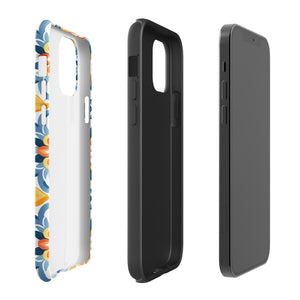 Statement Cases' Mediterranean Bloom for iPhone is showcased, featuring an intricate, colorful pattern. The design includes blue, yellow, and orange floral shapes in a symmetrical arrangement on a light blue background. This durable phone case provides dual-layer protection and is constructed from impact-resistant polycarbonate to safeguard your device.