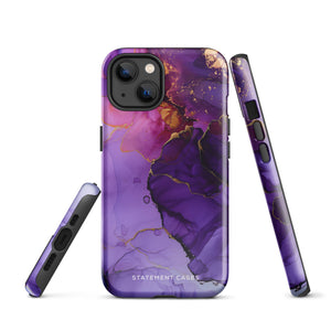 A Statement Cases Golden Orchid Marble for iPhone with a case featuring an abstract design of swirling purple, pink, and gold hues over a white background. The marbled patterns with metallic accents provide dual-layer protection and are impact-resistant. The top of the case has cutouts for the phone's camera lenses and is induction charging compatible.