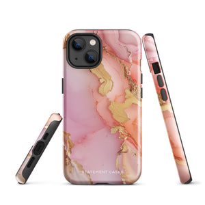 The Gold Blush Marble for iPhone showcases a glossy, marble-patterned case in shades of pink and gold. The decorative design features swirling patterns, seamlessly blending the colors. Crafted with impact-resistant polycarbonate for superior phone protection, "Statement Cases" is written in white at the bottom.