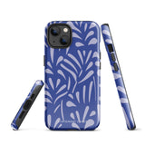 An iPhone encased in the "Mariposa Azul" by Statement Cases, featuring a blue design with an abstract white leaf pattern. The case combines curved and pointed shapes and provides dual-layer protection with TPU lining and impact-resistant polycarbonate. Camera lenses and other top elements remain unobstructed, and "Statement Cases" is inscribed at the bottom.