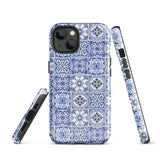 The Lisboa Azul for iPhone by Statement Cases is a smartphone adorned with a dual-layer protection phone case, featuring an intricate blue and white tile pattern. The design showcases various geometric and floral motifs, forming a visually appealing mosaic effect. The impact-resistant camera lenses and flash are prominently visible at the top left.