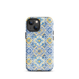 The Blue Mirage for iPhone by Statement Cases features a dual-layered, impact-resistant polycarbonate exterior with a TPU inner liner. Inspired by traditional Portuguese tiles, the blue and yellow patterned case boasts an intricate design of floral and geometric motifs. With its elegant and colorful appearance, the phone's camera is visible at the top left of the case.