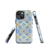 The Blue Mirage for iPhone by Statement Cases features a dual-layered, impact-resistant polycarbonate exterior with a TPU inner liner. Inspired by traditional Portuguese tiles, the blue and yellow patterned case boasts an intricate design of floral and geometric motifs. With its elegant and colorful appearance, the phone's camera is visible at the top left of the case.