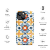 Statement Cases' Mediterranean Bloom for iPhone is showcased, featuring an intricate, colorful pattern. The design includes blue, yellow, and orange floral shapes in a symmetrical arrangement on a light blue background. This durable phone case provides dual-layer protection and is constructed from impact-resistant polycarbonate to safeguard your device.