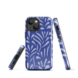 An iPhone encased in the "Mariposa Azul" by Statement Cases, featuring a blue design with an abstract white leaf pattern. The case combines curved and pointed shapes and provides dual-layer protection with TPU lining and impact-resistant polycarbonate. Camera lenses and other top elements remain unobstructed, and "Statement Cases" is inscribed at the bottom.