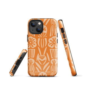 A Savannah Ardiente for iPhone from Statement Cases, featuring a dual-layered phone case in orange with a floral pattern showcasing cream-colored flowers, leaves, and geometric shapes. This impact-resistant polycarbonate case displays "STATEMENT CASES" at the bottom and reveals the camera lenses at the top left corner.