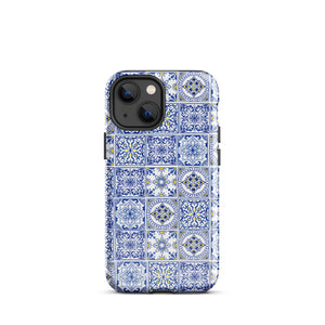 The Lisboa Azul for iPhone by Statement Cases is a smartphone adorned with a dual-layer protection phone case, featuring an intricate blue and white tile pattern. The design showcases various geometric and floral motifs, forming a visually appealing mosaic effect. The impact-resistant camera lenses and flash are prominently visible at the top left.