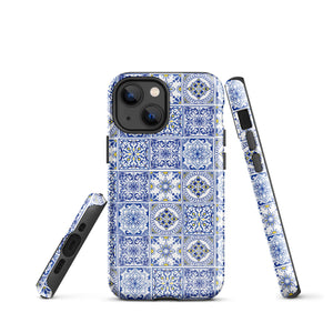 The Lisboa Azul for iPhone by Statement Cases is a smartphone adorned with a dual-layer protection phone case, featuring an intricate blue and white tile pattern. The design showcases various geometric and floral motifs, forming a visually appealing mosaic effect. The impact-resistant camera lenses and flash are prominently visible at the top left.