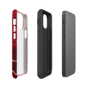 A smartphone in a protective Scarlet Marble for iPhone case by Statement Cases with a red and gold marbled abstract design. The case has "Statement Cases" written at the bottom. The iPhone 15 Pro Max features three camera lenses and a flash on the top left corner.