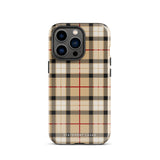 A Neutral Heritage Tartan for iPhone by Statement Cases with a plaid-patterned, impact-resistant polycarbonate case featuring beige, black, white, and red stripes. The durable phone case has the text "STATEMENT CASES" written at the bottom. The phone boasts a triple camera setup with an additional sensor and flash.