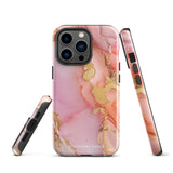 The Gold Blush Marble for iPhone showcases a glossy, marble-patterned case in shades of pink and gold. The decorative design features swirling patterns, seamlessly blending the colors. Crafted with impact-resistant polycarbonate for superior phone protection, "Statement Cases" is written in white at the bottom.