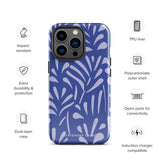 An iPhone encased in the "Mariposa Azul" by Statement Cases, featuring a blue design with an abstract white leaf pattern. The case combines curved and pointed shapes and provides dual-layer protection with TPU lining and impact-resistant polycarbonate. Camera lenses and other top elements remain unobstructed, and "Statement Cases" is inscribed at the bottom.