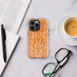 A Savannah Ardiente for iPhone from Statement Cases, featuring a dual-layered phone case in orange with a floral pattern showcasing cream-colored flowers, leaves, and geometric shapes. This impact-resistant polycarbonate case displays "STATEMENT CASES" at the bottom and reveals the camera lenses at the top left corner.