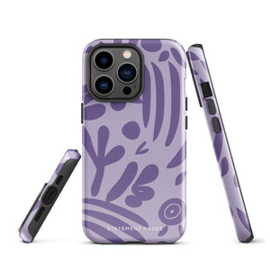 The Luna Morada for iPhone by Statement Cases is a durable phone case with a purple protective exterior featuring abstract dark purple and lavender patterns. The design includes geometric shapes and curves, giving it a modern artistic look. Made from impact-resistant polycarbonate, the lower part of the case prominently displays "STATEMENT CASES.