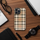 A Neutral Heritage Tartan for iPhone by Statement Cases with a plaid-patterned, impact-resistant polycarbonate case featuring beige, black, white, and red stripes. The durable phone case has the text "STATEMENT CASES" written at the bottom. The phone boasts a triple camera setup with an additional sensor and flash.