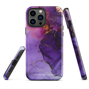 A Statement Cases Golden Orchid Marble for iPhone with a case featuring an abstract design of swirling purple, pink, and gold hues over a white background. The marbled patterns with metallic accents provide dual-layer protection and are impact-resistant. The top of the case has cutouts for the phone's camera lenses and is induction charging compatible.