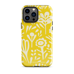 The Sol Dorado for iPhone by Statement Cases is a smartphone with a yellow case featuring a white, abstract floral and plant pattern. The camera lenses are prominent in the top left corner of the device. With dual-layer protection and impact-resistant TPU lining, "Statement Cases" is printed at the bottom of the case.