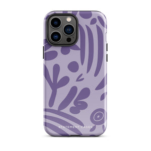 The Luna Morada for iPhone by Statement Cases is a durable phone case with a purple protective exterior featuring abstract dark purple and lavender patterns. The design includes geometric shapes and curves, giving it a modern artistic look. Made from impact-resistant polycarbonate, the lower part of the case prominently displays "STATEMENT CASES.