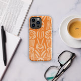 A Savannah Ardiente for iPhone from Statement Cases, featuring a dual-layered phone case in orange with a floral pattern showcasing cream-colored flowers, leaves, and geometric shapes. This impact-resistant polycarbonate case displays "STATEMENT CASES" at the bottom and reveals the camera lenses at the top left corner.