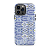 The Lisboa Azul for iPhone by Statement Cases is a smartphone adorned with a dual-layer protection phone case, featuring an intricate blue and white tile pattern. The design showcases various geometric and floral motifs, forming a visually appealing mosaic effect. The impact-resistant camera lenses and flash are prominently visible at the top left.