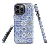 The Lisboa Azul for iPhone by Statement Cases is a smartphone adorned with a dual-layer protection phone case, featuring an intricate blue and white tile pattern. The design showcases various geometric and floral motifs, forming a visually appealing mosaic effect. The impact-resistant camera lenses and flash are prominently visible at the top left.