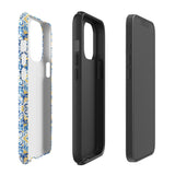 The Blue Mirage for iPhone by Statement Cases features a dual-layered, impact-resistant polycarbonate exterior with a TPU inner liner. Inspired by traditional Portuguese tiles, the blue and yellow patterned case boasts an intricate design of floral and geometric motifs. With its elegant and colorful appearance, the phone's camera is visible at the top left of the case.