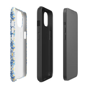 The Blue Mirage for iPhone by Statement Cases features a dual-layered, impact-resistant polycarbonate exterior with a TPU inner liner. Inspired by traditional Portuguese tiles, the blue and yellow patterned case boasts an intricate design of floral and geometric motifs. With its elegant and colorful appearance, the phone's camera is visible at the top left of the case.