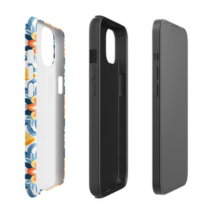 Statement Cases' Mediterranean Bloom for iPhone is showcased, featuring an intricate, colorful pattern. The design includes blue, yellow, and orange floral shapes in a symmetrical arrangement on a light blue background. This durable phone case provides dual-layer protection and is constructed from impact-resistant polycarbonate to safeguard your device.