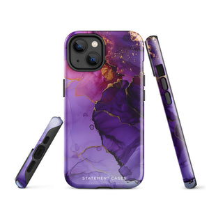 A Statement Cases Golden Orchid Marble for iPhone with a case featuring an abstract design of swirling purple, pink, and gold hues over a white background. The marbled patterns with metallic accents provide dual-layer protection and are impact-resistant. The top of the case has cutouts for the phone's camera lenses and is induction charging compatible.