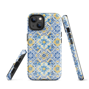 The Blue Mirage for iPhone by Statement Cases features a dual-layered, impact-resistant polycarbonate exterior with a TPU inner liner. Inspired by traditional Portuguese tiles, the blue and yellow patterned case boasts an intricate design of floral and geometric motifs. With its elegant and colorful appearance, the phone's camera is visible at the top left of the case.