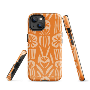 A Savannah Ardiente for iPhone from Statement Cases, featuring a dual-layered phone case in orange with a floral pattern showcasing cream-colored flowers, leaves, and geometric shapes. This impact-resistant polycarbonate case displays "STATEMENT CASES" at the bottom and reveals the camera lenses at the top left corner.