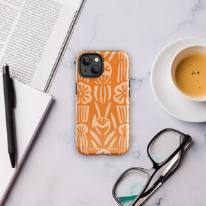 A Savannah Ardiente for iPhone from Statement Cases, featuring a dual-layered phone case in orange with a floral pattern showcasing cream-colored flowers, leaves, and geometric shapes. This impact-resistant polycarbonate case displays "STATEMENT CASES" at the bottom and reveals the camera lenses at the top left corner.