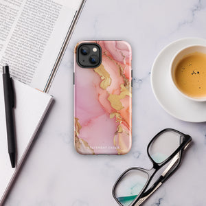 The Gold Blush Marble for iPhone showcases a glossy, marble-patterned case in shades of pink and gold. The decorative design features swirling patterns, seamlessly blending the colors. Crafted with impact-resistant polycarbonate for superior phone protection, "Statement Cases" is written in white at the bottom.