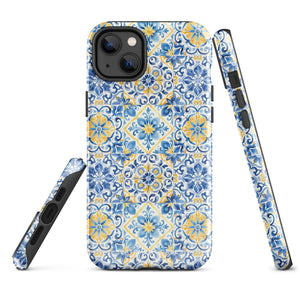 The Blue Mirage for iPhone by Statement Cases features a dual-layered, impact-resistant polycarbonate exterior with a TPU inner liner. Inspired by traditional Portuguese tiles, the blue and yellow patterned case boasts an intricate design of floral and geometric motifs. With its elegant and colorful appearance, the phone's camera is visible at the top left of the case.