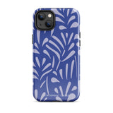 An iPhone encased in the "Mariposa Azul" by Statement Cases, featuring a blue design with an abstract white leaf pattern. The case combines curved and pointed shapes and provides dual-layer protection with TPU lining and impact-resistant polycarbonate. Camera lenses and other top elements remain unobstructed, and "Statement Cases" is inscribed at the bottom.