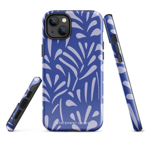 An iPhone encased in the "Mariposa Azul" by Statement Cases, featuring a blue design with an abstract white leaf pattern. The case combines curved and pointed shapes and provides dual-layer protection with TPU lining and impact-resistant polycarbonate. Camera lenses and other top elements remain unobstructed, and "Statement Cases" is inscribed at the bottom.