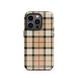 A Neutral Heritage Tartan for iPhone by Statement Cases with a plaid-patterned, impact-resistant polycarbonate case featuring beige, black, white, and red stripes. The durable phone case has the text "STATEMENT CASES" written at the bottom. The phone boasts a triple camera setup with an additional sensor and flash.